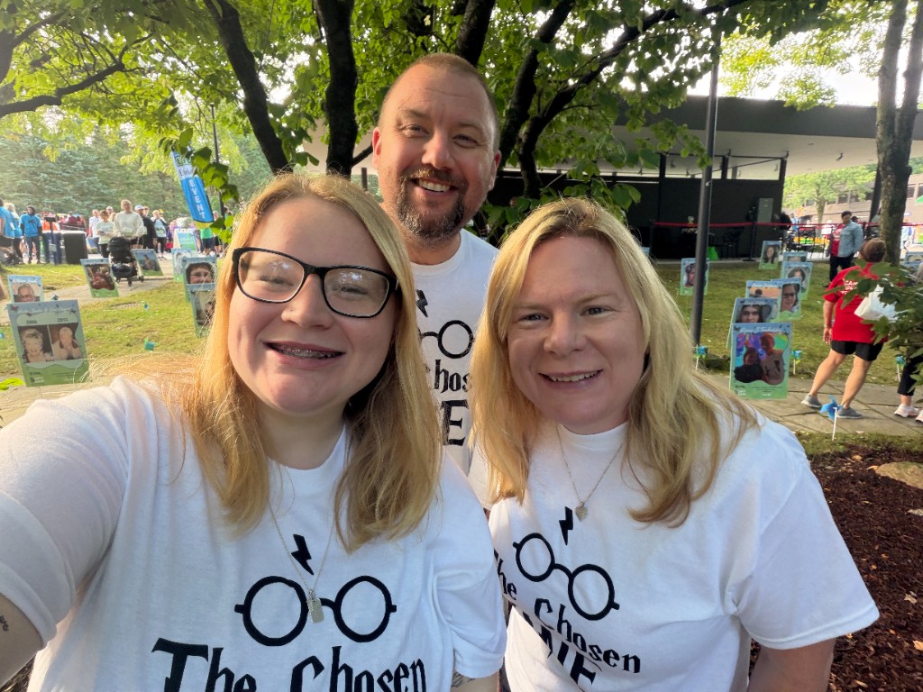 Members of the For A Child team smiling together at an outdoor community event